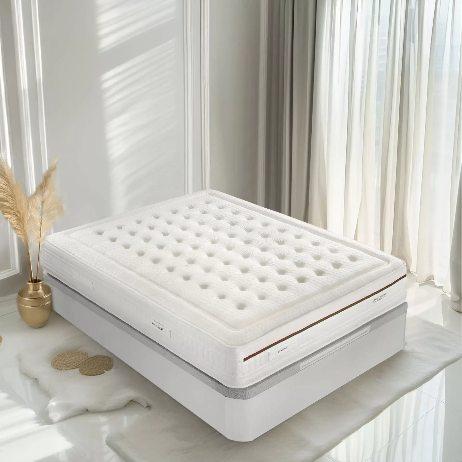 foto de colchón gran capitone sobre canapé blanco en una habitación en tonos blancos y una planta de decoración dorada